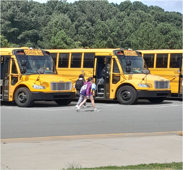 Students from Fuquay-Varina High School walk towards their buses