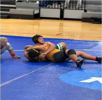 Junior Lucas Prestipino assists in the match win by gaining the final points needed with a pin.

