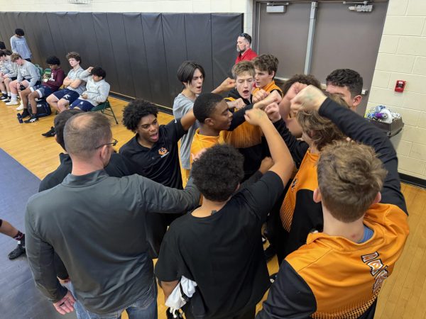 The FVHS wrestling team celebrates their performance as a team in a huddle. 