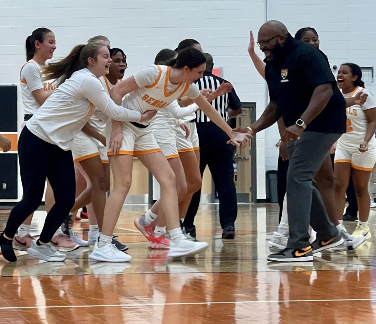 Sophomore Abigail Meaney celebrates with Coach Harrington and the team after her game winning basket.

