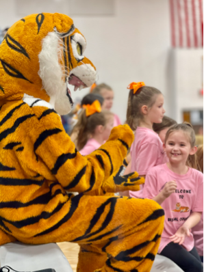 A young cheerleader plays rock, paper, scissors with Benny the Bengal.