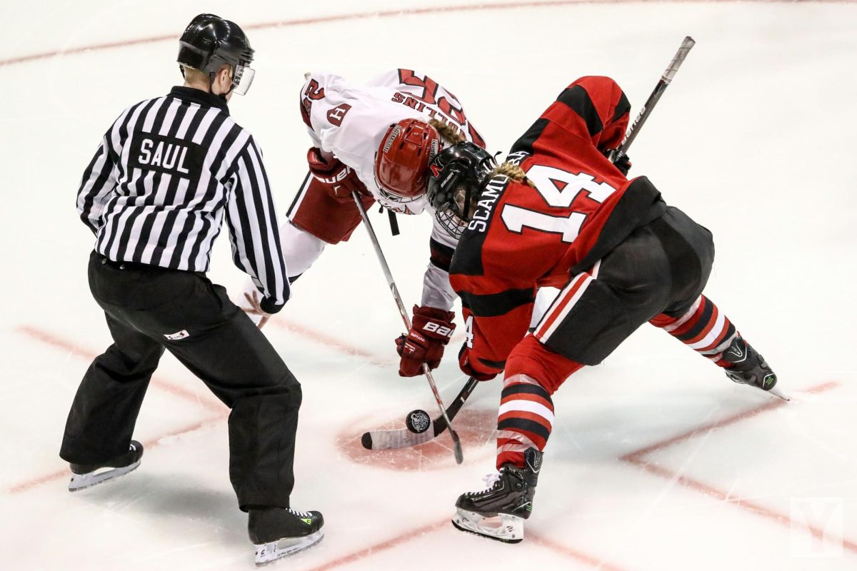 An intense faceoff as two opposing players battle for the puck.

