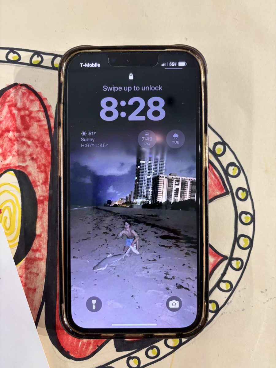Adam Stransky and a shark that he caught as his lockscreen on his iPhone.

