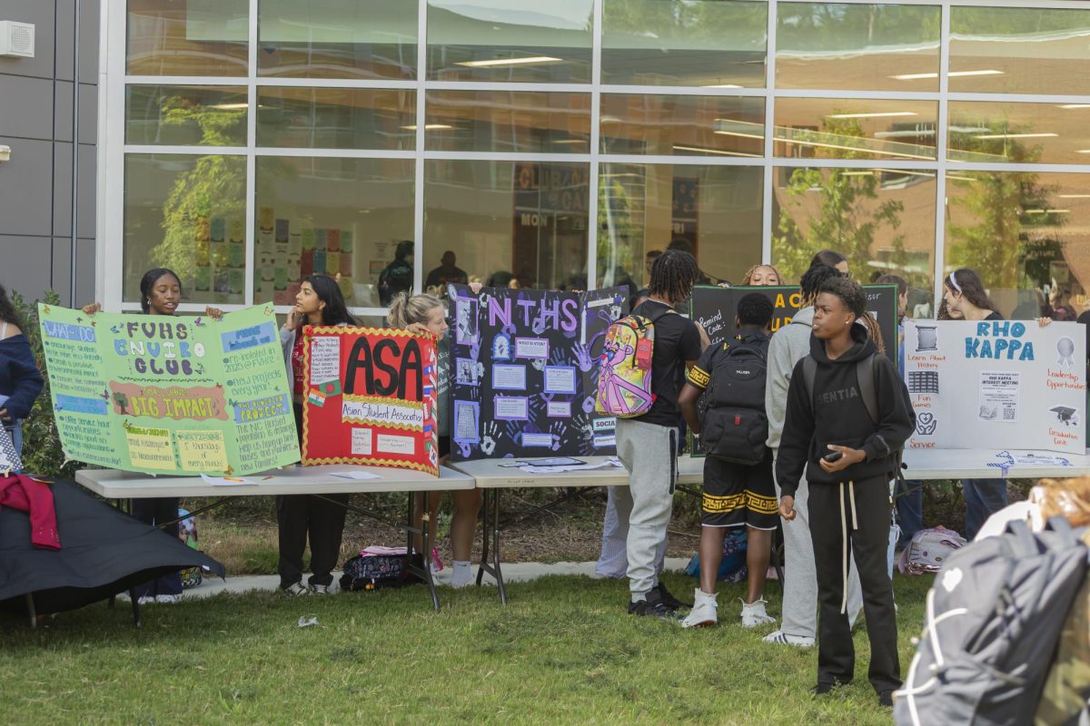 Students set up their display boards at the club fair in the courtyard.