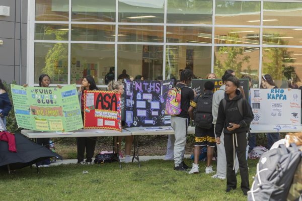 Students set up their display boards at the club fair in the courtyard.