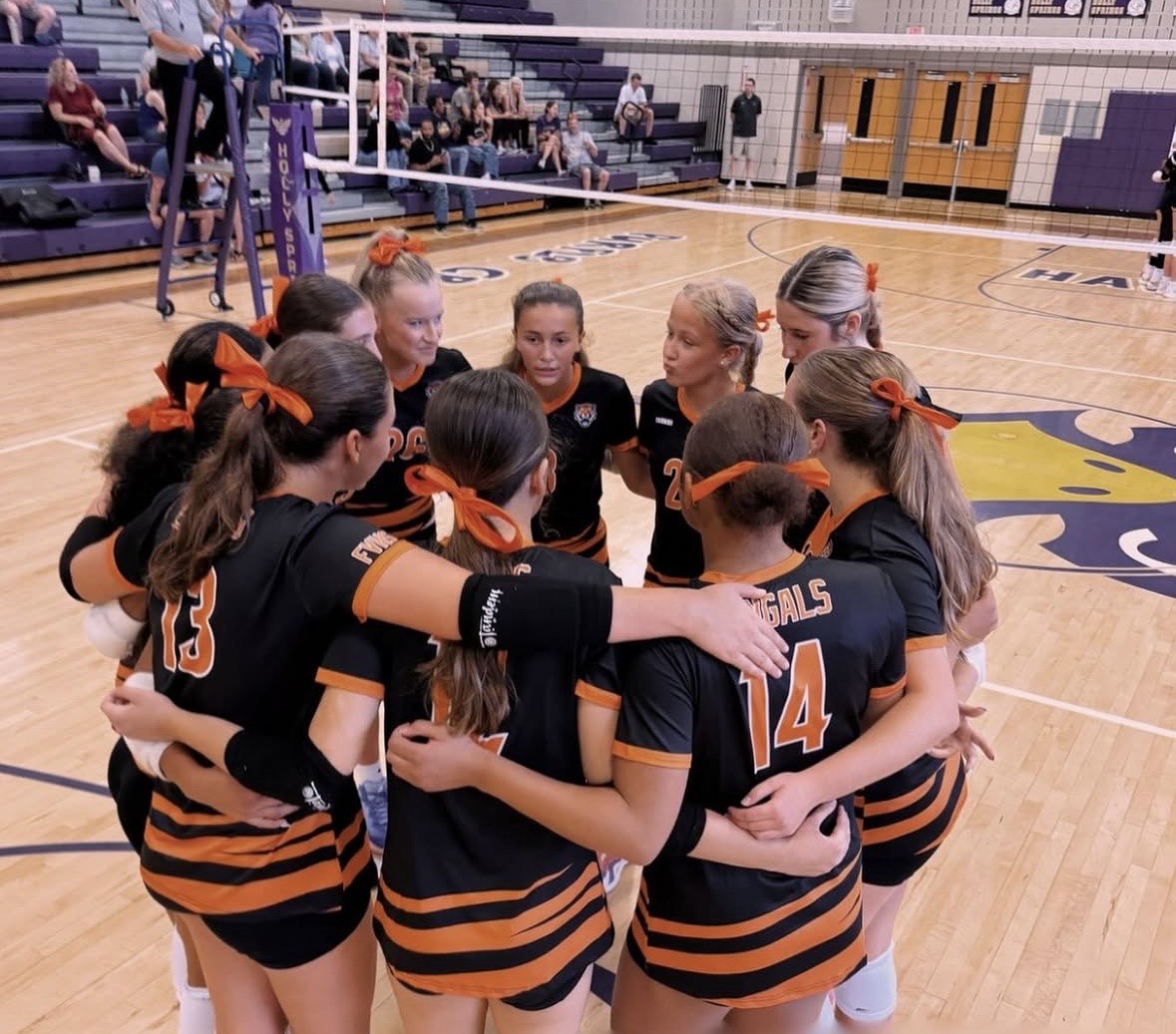 The FVHS JV-A team gathers before a game on the Holly Springs High School volleyball court.