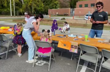 A volunteer helps a child at the slime making station at last year's trunk or treat.