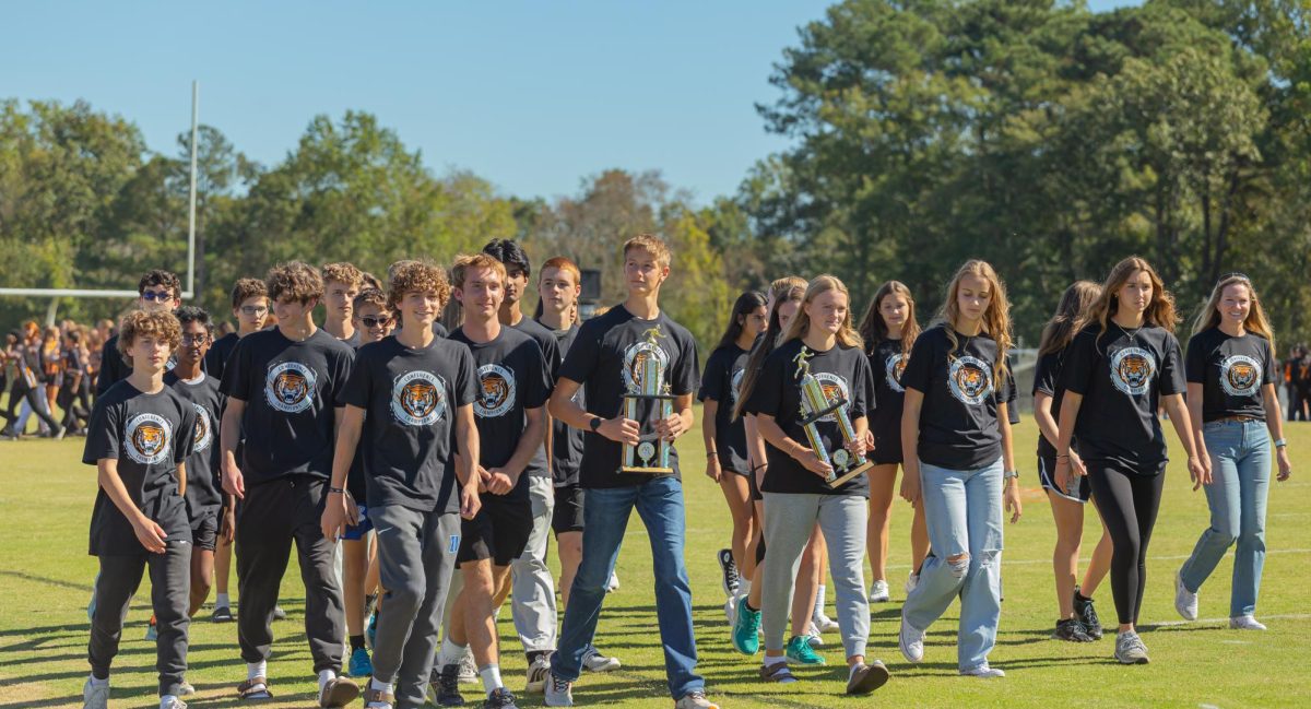 The cross country team shows off their trophies at the fall pep rally