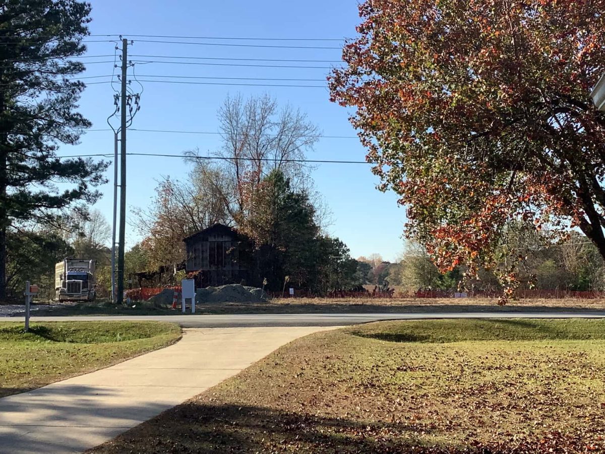 A truck pulls out of the construction site on Piney Grove Wilbon Rd. in Fuquay. The barn shown in front was torn down a few hours after this photo was taken. Photo by Marshall Ford.
