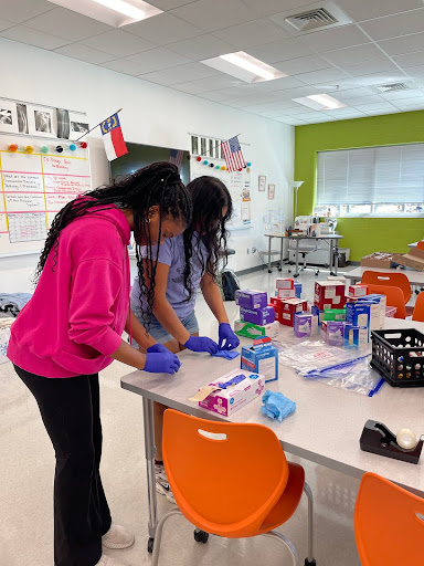 Former student Reva Dontha and senior Kenadi Johnson prepare The Ready Kits. Photo by Sana Sheth.