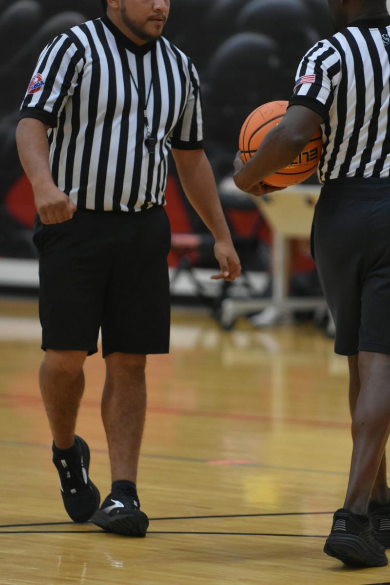 This seemingly innocent interaction on the court is exactly the kind of moment that fuels the fire of fans who believe referees' subjective decisions are consistently ruining the integrity of games. Photo by Lesli Whitecotton on Unsplash.