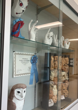 Student made masks and sculptures are displayed in a glass case at FVHS.