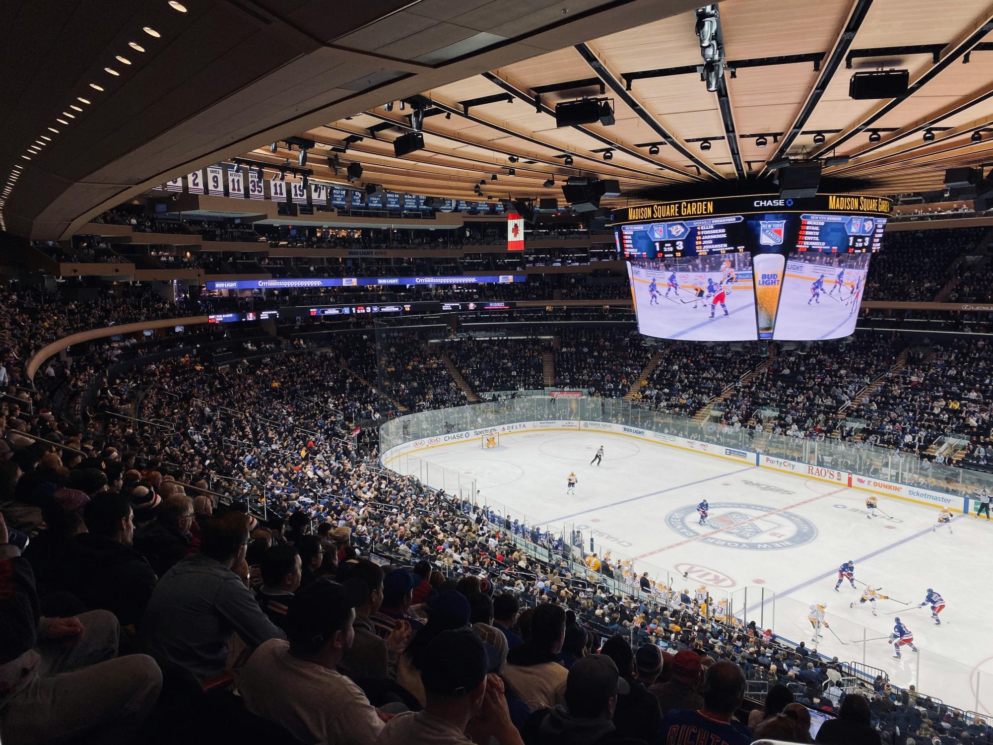 Fans cheer from packed seats during an exciting NHL playoff game at Madison Square Garden. 